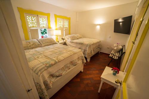 a hotel room with two beds and a television at Posada del Angel in Salento