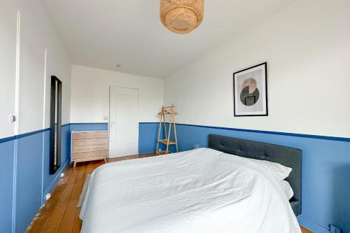 - une chambre bleue et blanche avec un grand lit dans l'établissement Beautiful private room in a Parisian shared apartment - Flexliving, à Paris