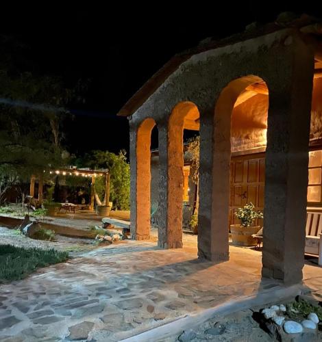 Un patio de piedra con arcos por la noche. en La Chakana, en Cachí