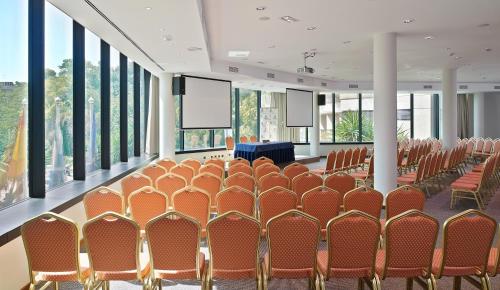 a conference room with rows of chairs and a podium at Hipotels Sherry Park in Jerez de la Frontera