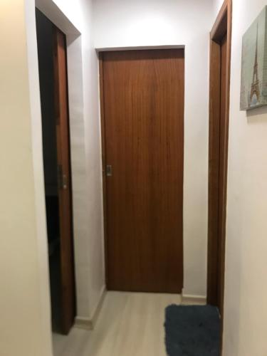 a hallway with a wooden door and a blue rug at AP ALPHA 5 STAr in Vespasiano