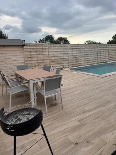 un patio avec une table et des chaises à côté d'une piscine dans l'établissement Superbe villa familiale avec piscine et spa, à Ambarès-et-Lagrave