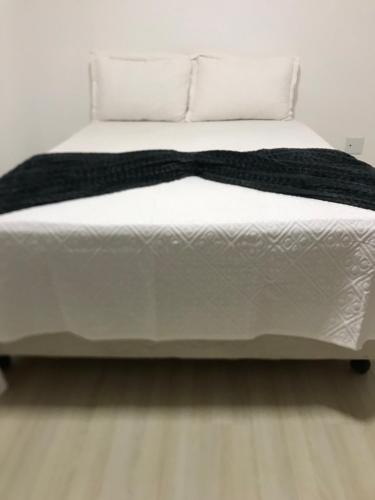 a white bed with a black bow tie on it at AP ALPHA 5 STAr in Vespasiano