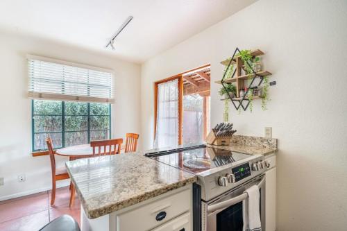 una cocina con estufa horno superior junto a una mesa en Vibrant 2BR DT Living, Stylish & Serene Stay, en Tucson