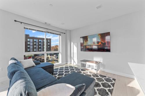 a living room with a blue couch and a large window at 2 Bedroom apartment in Revere