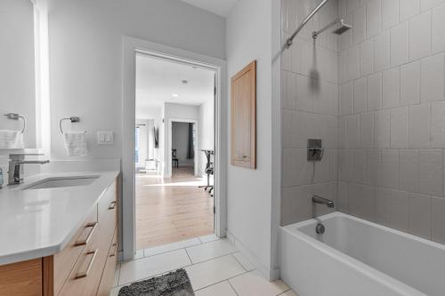 a white bathroom with a tub and a sink at 2 Bedroom apartment in Revere