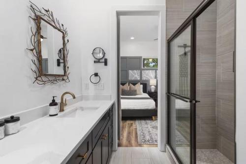 a bathroom with a sink and a mirror and a bed at Walk Geodis Stadium Restaurants Rooftop EV Garage in Nashville