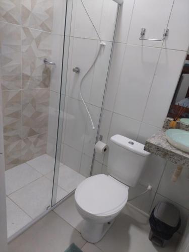 a white bathroom with a shower and a toilet at Maravilha do Patacho in Pôrto de Pedras