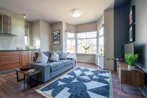 a living room with a blue couch and a kitchen at Park View, Sheffield in Sheffield