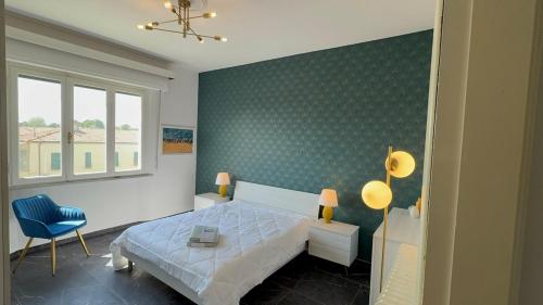 a bedroom with a bed and a blue chair at Lorenzo s House Nearby Leaning Tower Free Parking in Pisa