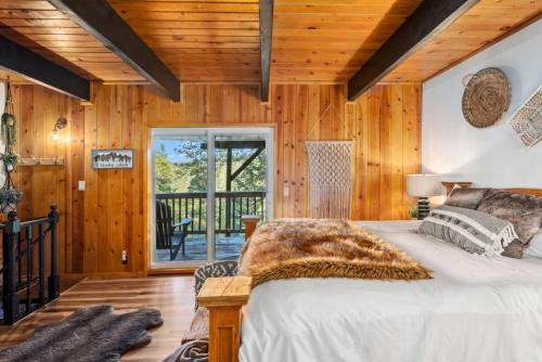 Un dormitorio con paredes de madera y una cama en una habitación. en A-Frame Luxury Escape, en Big Bear Lake
