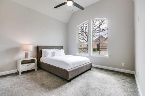 una camera da letto bianca con un letto e una finestra di Spacious and Modern 4BR 2BA 5MintoDFW a Lewisville
