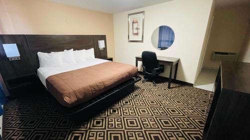 a hotel room with a bed and a desk at Falls Lodge & Suites in Niagara Falls