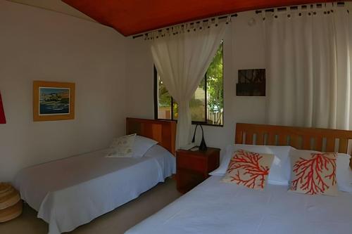 a bedroom with two beds and a window at Tu Casa de playa frente al mar, Tolú te espera in Tolú