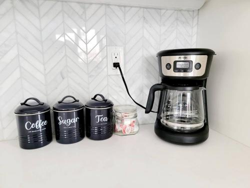a coffee maker on a counter next to four trash cans at Upscale Modern Townhouse at Balboa Park in San Diego