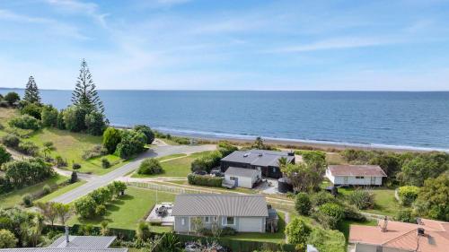 an aerial view of a house and the ocean at WaveSong Cottage - Your Escape by the Sea in Parapara 