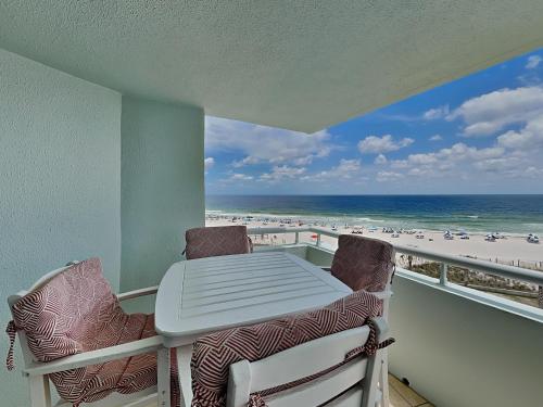 a balcony with a table and chairs and the beach at Perdido Sun #410 in Perdido Key