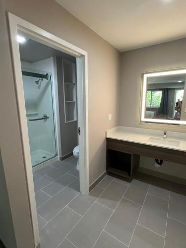 a bathroom with a shower and a sink and a mirror at Northern Queen Inn in Nevada City
