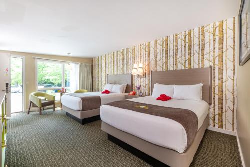 a hotel room with two beds and a desk at Bar Harbor Motel in Bar Harbor