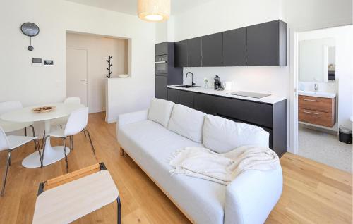 a living room with a white couch and a kitchen at 1 Bedroom Amazing Apartment In Oostende in Ostend