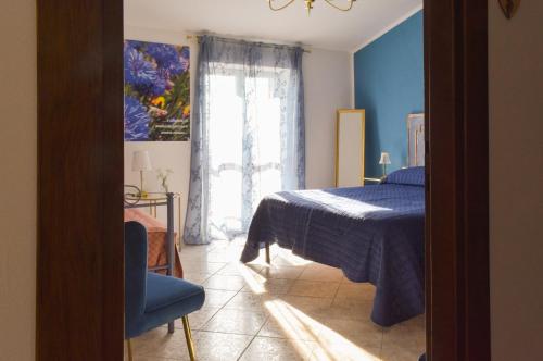 a blue bedroom with a bed and a window at Domus Aromatica in Assisi