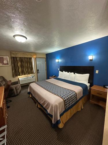 a bedroom with a large bed with a blue wall at Eco-Lux Inn Norfolk in Norfolk