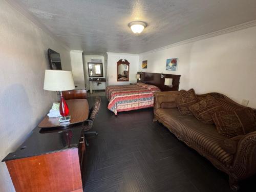 a hotel room with a couch and a bed at Vista Motel - Riverside in Riverside