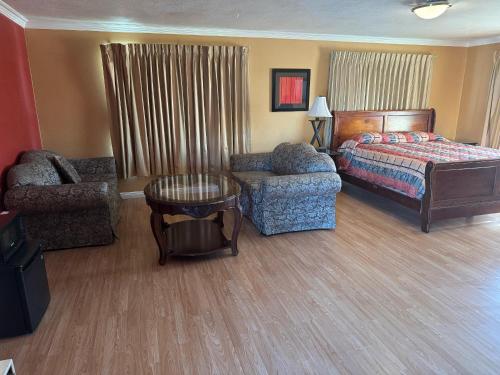 a bedroom with a bed and a couch and a chair at Vista Motel - Riverside in Riverside