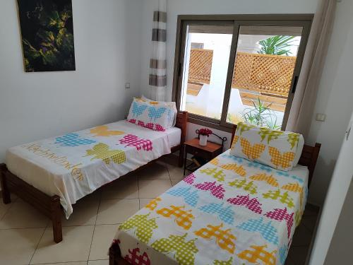 a room with two beds and a window at Beralmar Asilah Chez FATIMA in Asilah