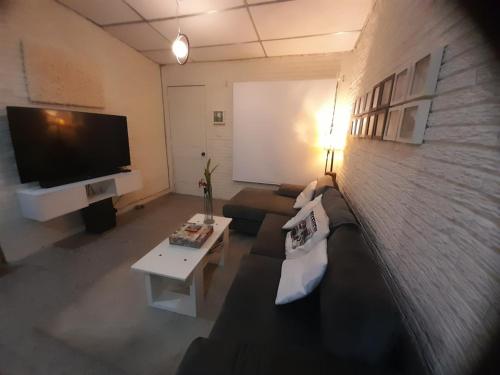 a living room with a couch and a flat screen tv at La Cima House-Studio in San Salvador