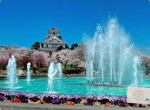 a fountain in front of a building with a tower at 長浜ゲストハウス楽市 in Nagahama