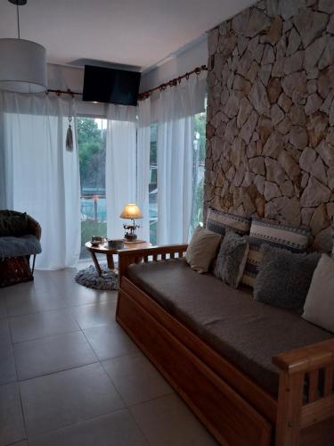 a bedroom with a bed and a stone wall at Arena de Mar depto A in Mar de las Pampas