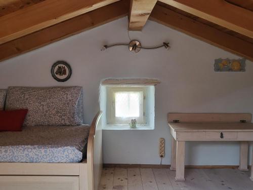 a bedroom with a bed and a window and a desk at Klunj home in Buje