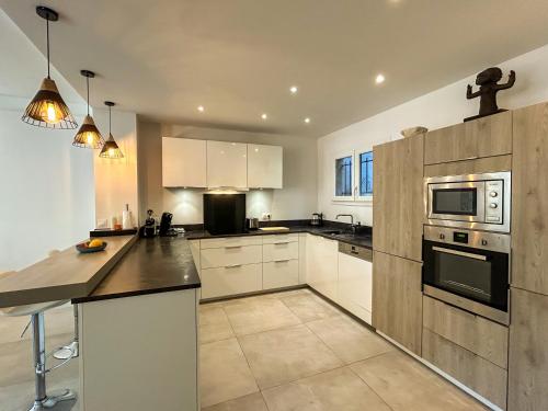 une cuisine avec des armoires blanches et un comptoir dans l'établissement La Corne dOr - Spacious 2-level villa with air conditioning, terrace and pool, à Villefranche-sur-Mer