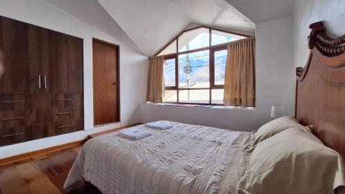 a bedroom with a large bed and a window at Caraz Miski Wuasi in Caraz