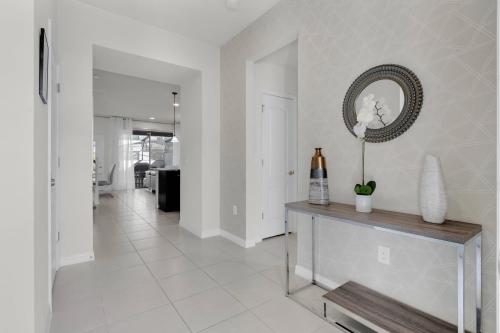a white hallway with a table with a flower on it at Exceptional House 5BD4.5BA Private Pool WW8907 in Kissimmee