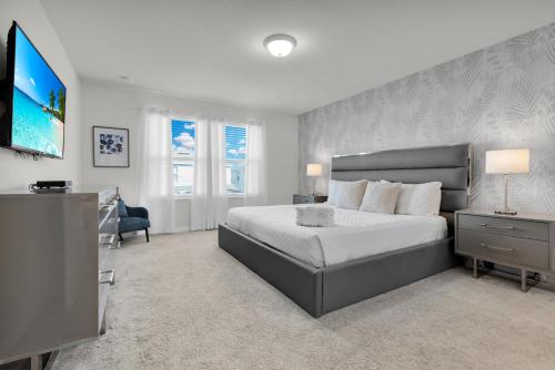 a bedroom with a bed and a flat screen tv at Exceptional House 5BD4.5BA Private Pool WW8907 in Kissimmee