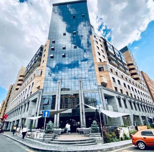 a large building with a glass facade on a street at Prime apartment in Buzand 17 with beautiful terrace in Yerevan