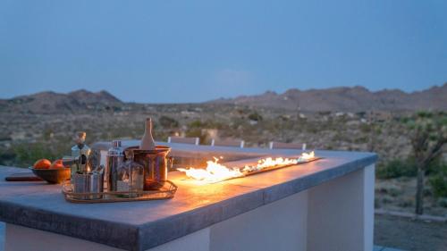 a fire burns on a table with a view of the desert at Desert Serenity Gateway To Joshua Tree in Joshua Tree