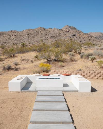 a white bench in the middle of the desert at Desert Serenity Gateway To Joshua Tree in Joshua Tree