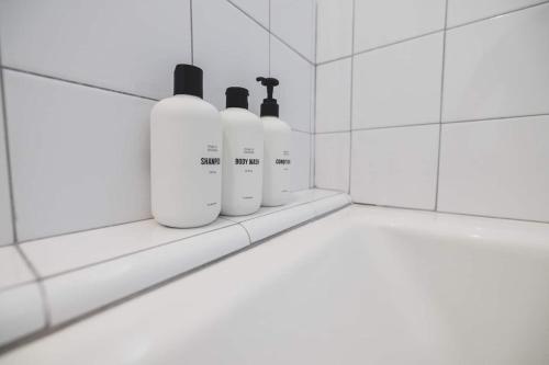 a bathroom with three soap bottles on a shelf at Desert Serenity Gateway To Joshua Tree in Joshua Tree