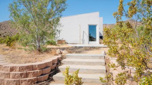 a house in the desert with stone steps at Desert Serenity Gateway To Joshua Tree in Joshua Tree