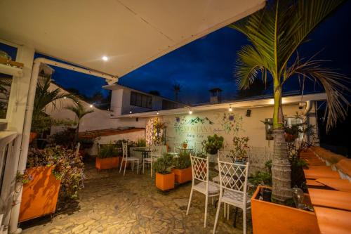 a patio with a table and chairs and a palm tree at Posada del Angel in Salento