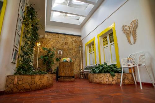 a hallway with a yellow door and some plants at Posada del Angel in Salento