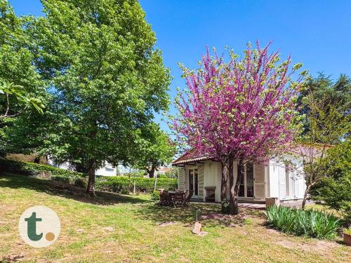a house with a pink flowering tree in the yard at Tranquiloue - Halte Nature Proche du PuyduFou in Saint-Laurent-sur-Sèvre