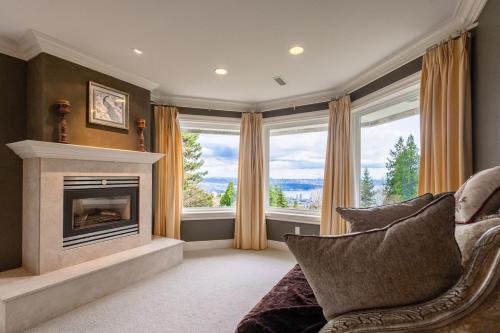 a living room with a fireplace and a couch at Luxury 5BR Villa, Gym, Theater & Ocean Views in West Vancouver