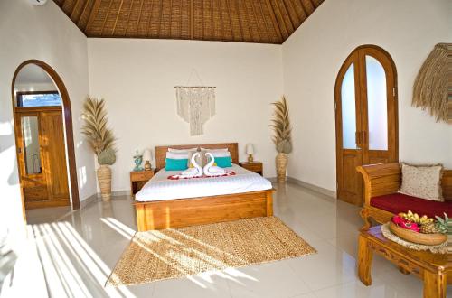 a bedroom with a bed and a chair at Romantic Villa in Ubud Private Pooll and Rice Fields View in Ubud