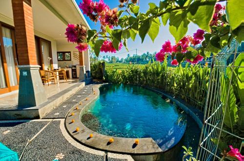 a swimming pool in a garden with flowers at Romantic Villa in Ubud Private Pooll and Rice Fields View in Ubud