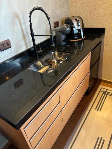 a kitchen counter with a sink and a mixer at Chalé Manacá in Sapucaí-Mirim