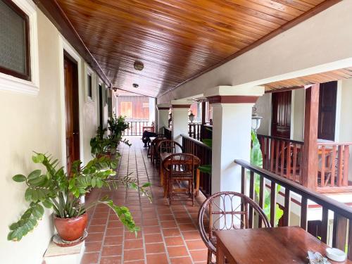 a porch with tables and chairs on a balcony at Golden Sun Hotel in Luang Prabang